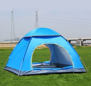 Blue waterproof camping tent with large single door set up on green grass outdoors